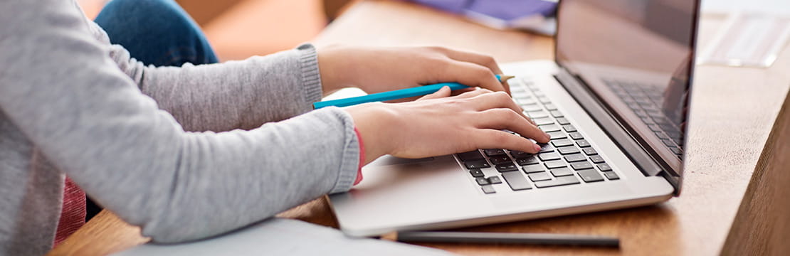 Child using a laptop while learning safe online habits.